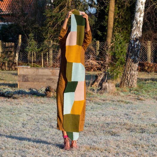 Anna Husemann holding her Forming scarf up in the air on a icy winter morning.